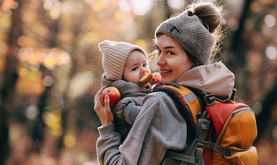 Mutter mit Baby isst einen gesunden Apfel